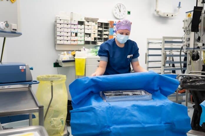 steriele doeken - foto van o.k.-verpleegkundige die instrumenten uit steriele doeken haalt