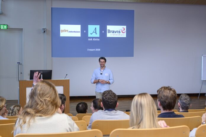 Colegezaal met screen waarop logo's te zien zijn van deelnemers aan de studie (Gelre, Bravis, Ask Aletta)