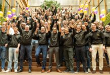 Groepsfoto van RYSE-personeel op een trap met ballonnen