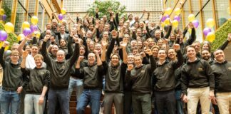 Groepsfoto van RYSE-personeel op een trap met ballonnen